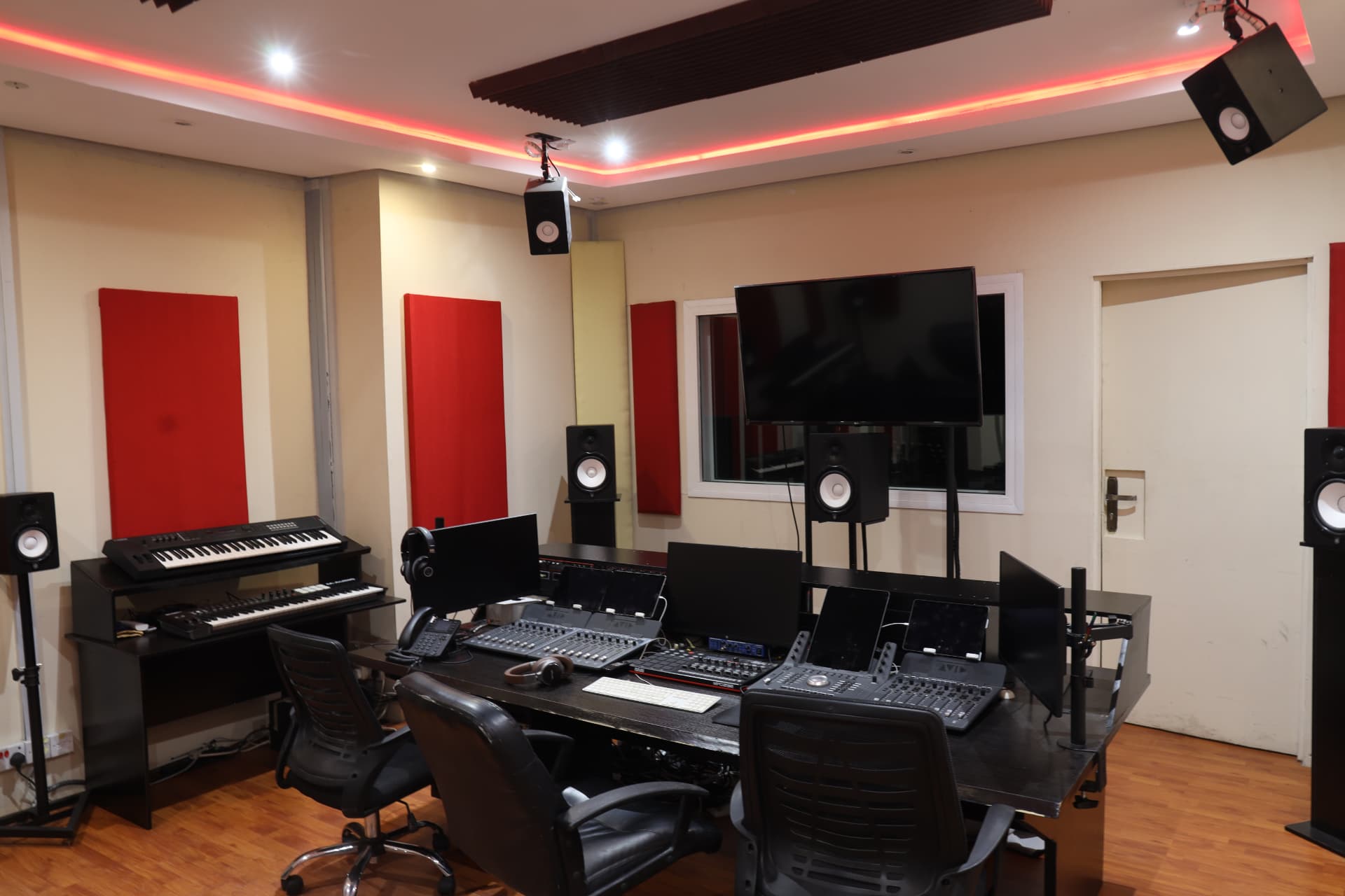 Wide view of Sound Suite 1 with keyboards, speakers, console and overhead monitor