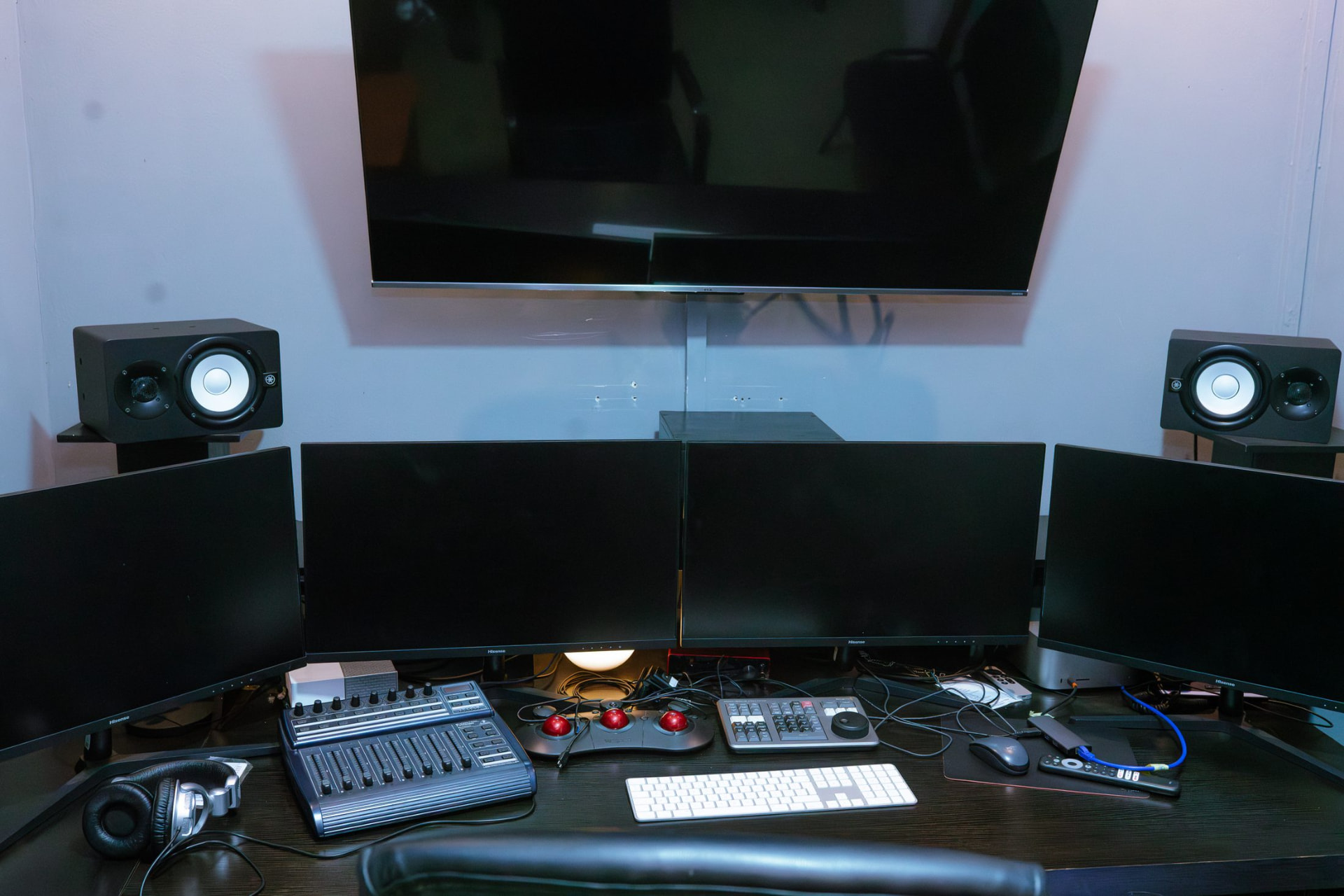 4K video editing suite with multi-monitor desk, control surface and near-field speakers