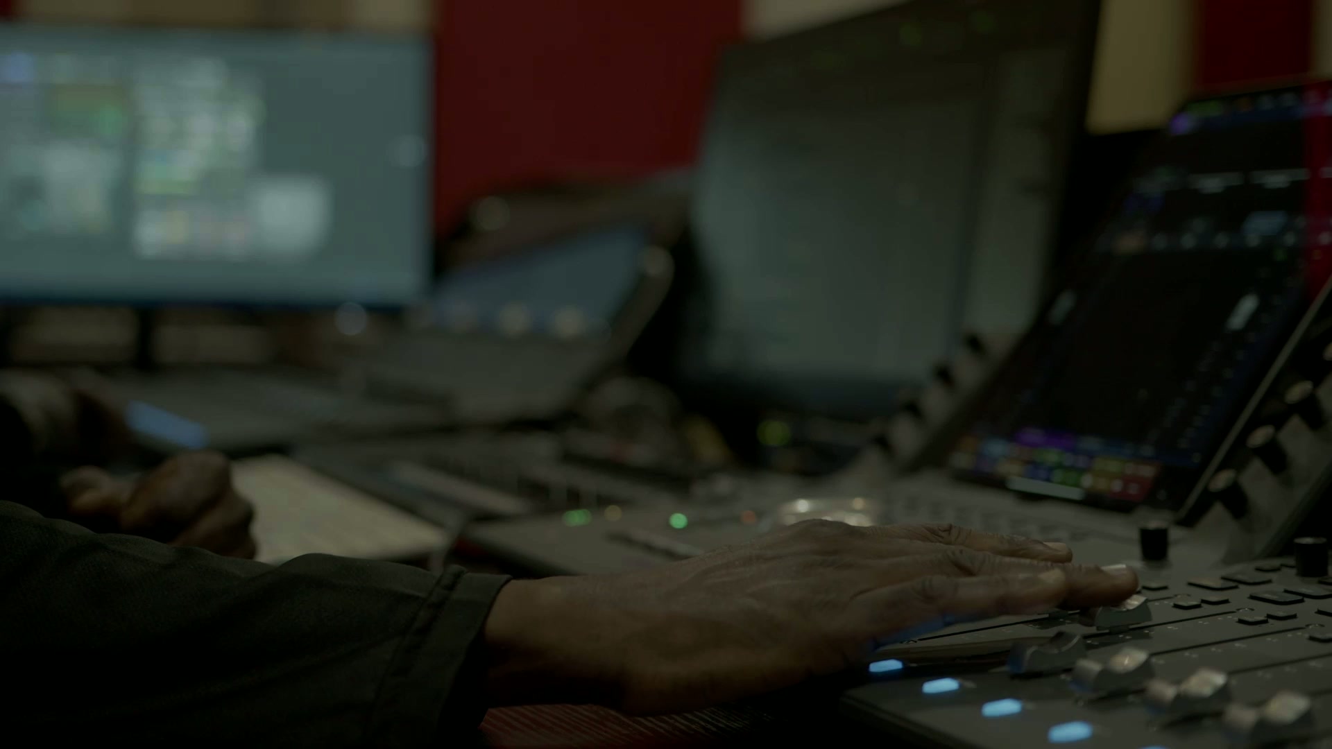 Engineer's hand riding the faders on the Digitrack mixing console