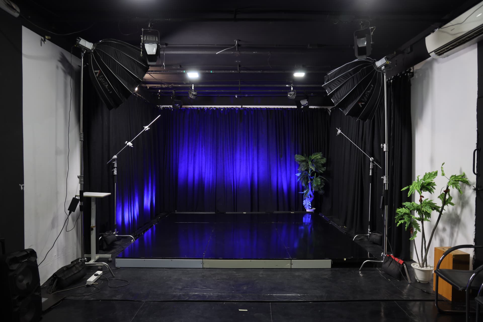 Studio B floor with raised black platform, blue-lit curtains and Light Dome II softboxes