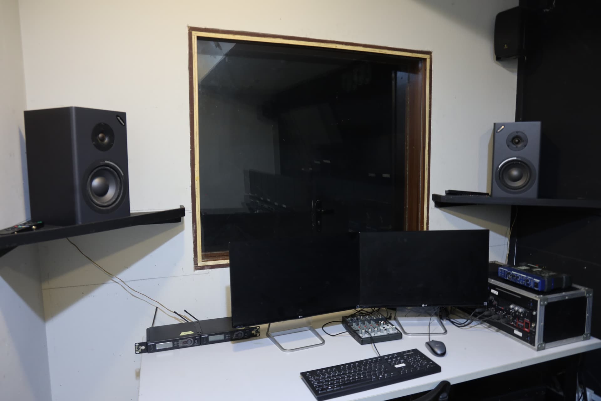 Editing booth overlooking Control Room B at Digitrack Studios with monitors and rack gear